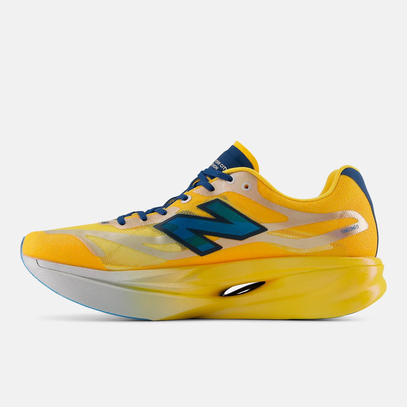 Medial side of the New Balance SuperComp Elite v6 TCS NYC Marathon showing the FANTOMFIT callout, the open window in the yellow heel midsole and a pale blue outsole edge