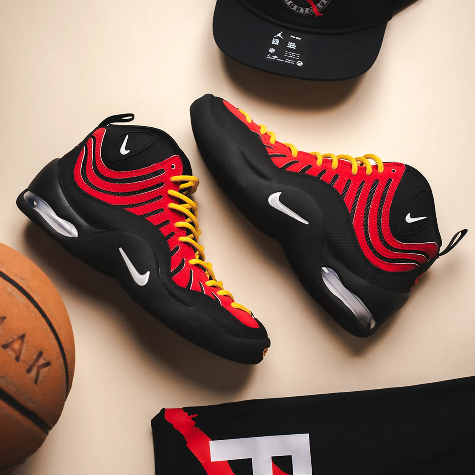 Nike Air Bakin High SP in Varsity Red and Black alongside a basketball and jersey