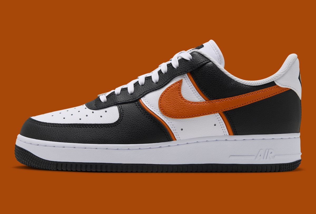 Lateral view of the Nike Air Force 1 Low Campfire Orange with a black leather mudguard and orange Swoosh over a white leather base