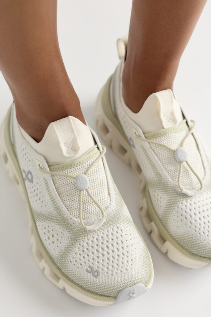 On x FP Movement Cloud X Tempo in Ivory and Chalk worn on foot, showing the engineered mesh upper and toggle lace pulls