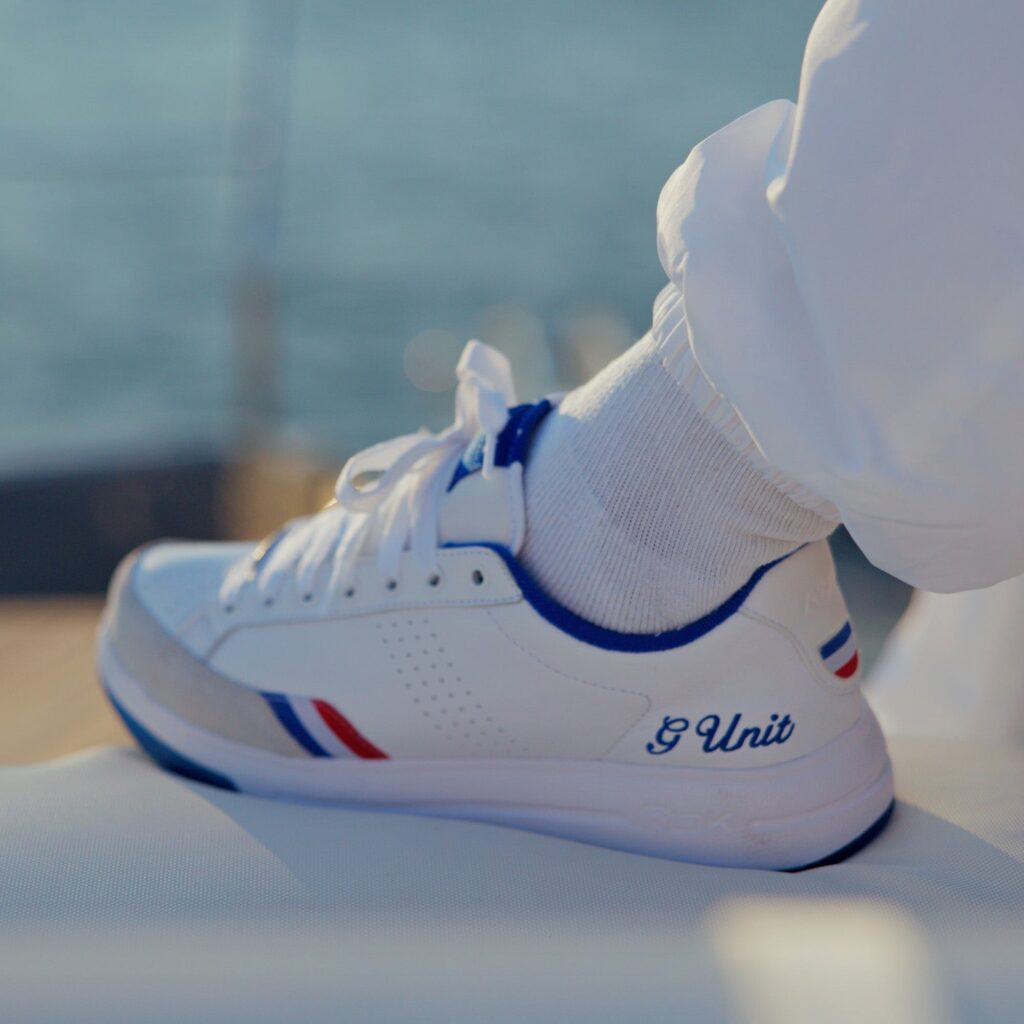 Reebok x G-Unit G6 in White, Blue and Red worn on foot, showing the G Unit script on the heel and the tricolour stripe