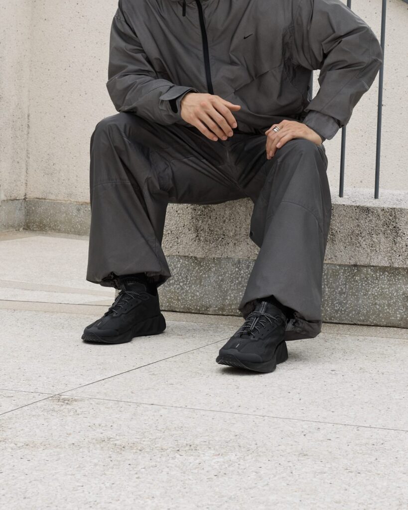 Nike Ava X SE in Black, Anthracite and Dark Grey worn on steps